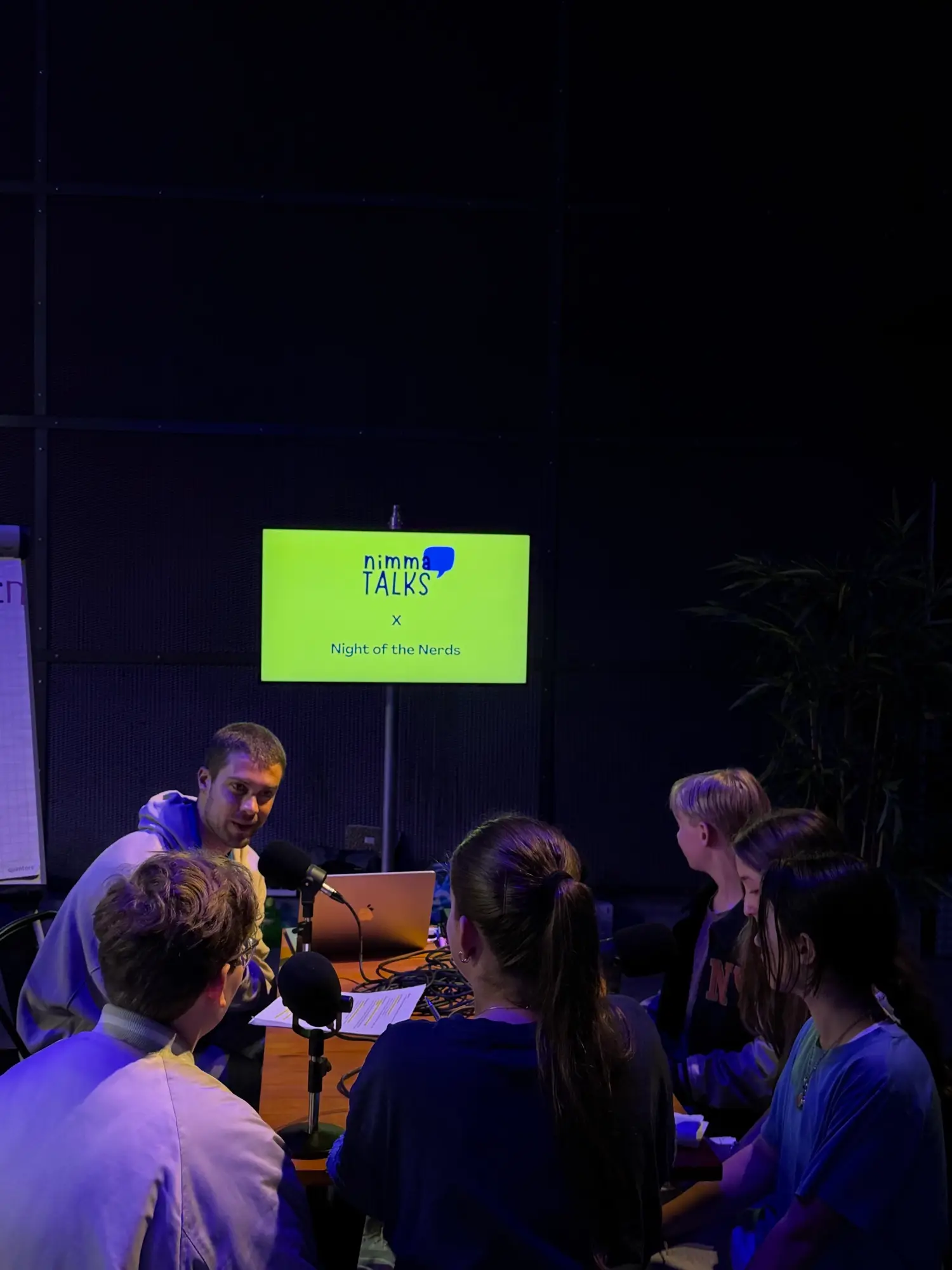 Jongeren rond microfoons tijdens een podcast-opname van Nimma Talks